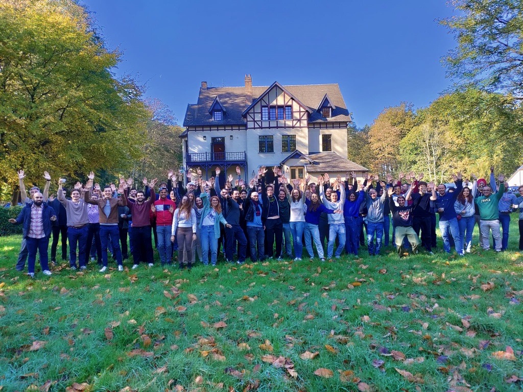 Group of people from Proximus Ada taking joyful picture and raising their hands